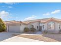 Front view of a single-story house with a garage and landscaping at 7859 Lisa Marie Ct, Las Vegas, NV 89113