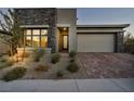 Modern home with stone and stucco exterior, two-car garage at 928 Calluna Hills Ln, Las Vegas, NV 89138