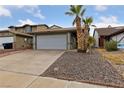 House exterior with a two car garage and palm trees at 504 Crony Ave, Henderson, NV 89011