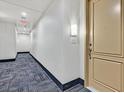 Clean hallway with carpet, showing a light-colored apartment door at 59 E Agate Ave # 406, Las Vegas, NV 89123