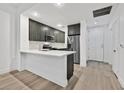 Modern kitchen with dark gray cabinets, white countertops, and stainless steel appliances at 59 E Agate Ave # 406, Las Vegas, NV 89123