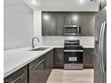 Modern kitchen with dark gray cabinets, white countertops, and stainless steel appliances at 59 E Agate Ave # 406, Las Vegas, NV 89123