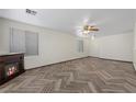 Spacious living room featuring an electric fireplace, ceiling fan, and wood-look floors at 610 Roberta Alecia Ave, North Las Vegas, NV 89031