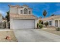 Two-story house with a white garage door and desert landscaping at 7214 Paradise Bay Dr, Las Vegas, NV 89119