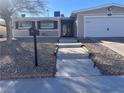 Single-story home with a two-car garage and well-maintained landscaping at 7221 Tempest Pl, Las Vegas, NV 89145