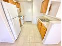 Galley kitchen with wood cabinets and tiled floor at 8250 N Grand Canyon Dr # 1105, Las Vegas, NV 89166