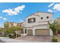 Two-story house with beige exterior, two-car garage, and landscaping at 9625 Ponderosa Skye Ct, Las Vegas, NV 89166