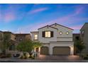 Two-story home boasts a beautiful front yard, brick driveway and a two-car garage at dusk at 9625 Ponderosa Skye Ct, Las Vegas, NV 89166