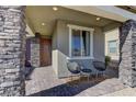 Covered porch with stone columns and comfortable seating at 319 Cooper Hawk Ct, Las Vegas, NV 89138
