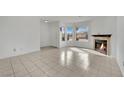 Bright living room boasts tile floors, a charming fireplace, and multiple windows offering natural light at 3891 Terrazzo Ave, Las Vegas, NV 89115