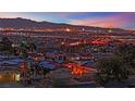 Night view of a residential area with city lights in the background at 476 Tiger Lily Way, Henderson, NV 89015