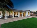 A beautiful backyard, showcasing a covered patio, lush turf, and elegant exterior of the home at 5130 Agio Ave, Pahrump, NV 89061