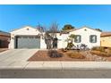 Charming single-story home featuring desert landscaping, a dark gray garage door, and neutral stucco siding at 5130 Agio Ave, Pahrump, NV 89061