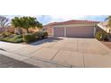 Single-story house with a three-car garage, landscaping, and large driveway at 585 Duran St, Henderson, NV 89015