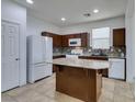 Modern kitchen with granite island, dark cabinets and tile floor at 7640 Houston Peak St, Las Vegas, NV 89166
