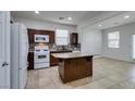 Modern kitchen with granite island, dark cabinets and tile floor at 7640 Houston Peak St, Las Vegas, NV 89166