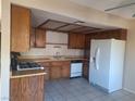 Kitchen with wood cabinetry, gas range, and white appliances at 6653 W Tropicana Ave # 101, Las Vegas, NV 89103