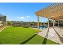 Inviting backyard oasis features a sparkling pool, lush grass, and pergola at 1343 Panini Dr, Henderson, NV 89052