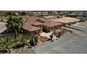 Single-story home with a tile roof, palm trees, and a gravel driveway at 2221 E Winery Rd, Pahrump, NV 89048