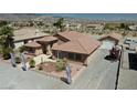 Single-story home with tile roof and landscaped yard, mountain view in background at 2221 E Winery Rd, Pahrump, NV 89048