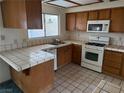 Kitchen with wood cabinets, white appliances, and tile countertops at 3160 James A Bilbray Pkwy, Laughlin, NV 89029