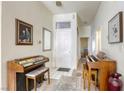 Bright entryway with tiled floor, two vintage organs, and framed artwork at 4773 Big Draw Dr, North Las Vegas, NV 89031