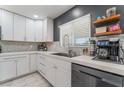 Modern kitchen with white shaker cabinets, stainless steel appliances, and herringbone backsplash at 4825 Greencreek Dr, Las Vegas, NV 89110