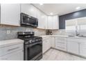 Modern kitchen with white cabinets, stainless steel appliances, and quartz countertops at 4825 Greencreek Dr, Las Vegas, NV 89110