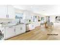 Modern white kitchen with quartz countertops and stainless steel appliances at 5153 Woodruff Pl, Las Vegas, NV 89120