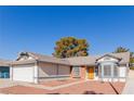 Single-story house exterior featuring a two-car garage and manicured lawn at 6200 Budnick Cir, Las Vegas, NV 89130