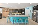 Modern kitchen with granite countertops, teal island, and stainless steel appliances at 685 Sea Star St, Henderson, NV 89002