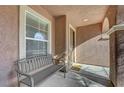 Small front porch with bench, entry door, and window at 7182 Hood River Ave, Las Vegas, NV 89179