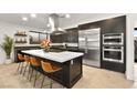 Modern kitchen with stainless steel appliances, large island with seating, and sleek dark cabinetry at 803 Bolide St, Las Vegas, NV 89138