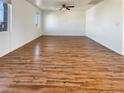 Bright, empty living room featuring hard wood flooring and a large window for natural light at 10809 Wrigley Field Ave, Las Vegas, NV 89166