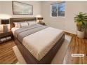 Comfortable staged main bedroom with plush carpet, a large window, neutral walls, and a stylish decor at 10809 Wrigley Field Ave, Las Vegas, NV 89166