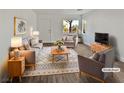 Virtually staged living room with modern furniture and wood-look floors at 3615 American Pie Ct, Las Vegas, NV 89129