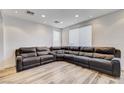 Living room with large sectional sofa and wood-look floors at 7324 Tin Mine Ave, Las Vegas, NV 89179