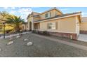Two-story house with tan siding, landscaping, and a palm tree in the front yard at 7611 Leybourne Ct, Las Vegas, NV 89131