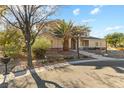 Two-story house with tan siding, landscaping, and a palm tree in the front yard at 7611 Leybourne Ct, Las Vegas, NV 89131