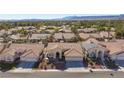 Areal view showing a well-planned neighborhood with mature landscaping, tile roofs and mountain views in the distance at 9109 Lazy Hill Cir, Las Vegas, NV 89117