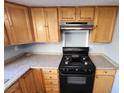 Kitchen with wood cabinets, granite counters, and black appliances at 1480 Hialeah Dr # B, Las Vegas, NV 89119