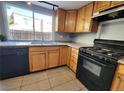 Kitchen with wood cabinets, granite counters, and black appliances at 1480 Hialeah Dr # B, Las Vegas, NV 89119