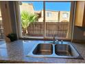 Kitchen sink with granite countertop and view of backyard at 1480 Hialeah Dr # B, Las Vegas, NV 89119