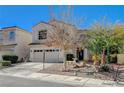 Two-story house with tan exterior, two car garage, and landscaping at 1805 Grand Rodeo St, Las Vegas, NV 89117