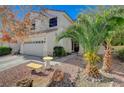 Two-story house with tan exterior, two car garage, and landscaping at 1805 Grand Rodeo St, Las Vegas, NV 89117