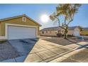 House exterior showcasing a tan house with a white garage door at 2210 Cool River Ct, North Las Vegas, NV 89032