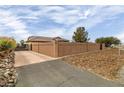 Long driveway leading to a home with a high block wall for privacy at 3361 Winery Rd, Pahrump, NV 89048