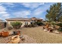 One-story house with a gravel yard, featuring terracotta pots and a wheelbarrow at 3361 Winery Rd, Pahrump, NV 89048