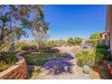 Lush backyard oasis with patio area, hot tub, and meticulously maintained landscaping at 36 Hunt Valley Trl, Henderson, NV 89052