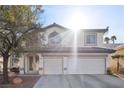 Bright exterior view of a two-story home with a three-car garage, desert landscaping, and tile roof at 41 Voltaire Ave, Henderson, NV 89002